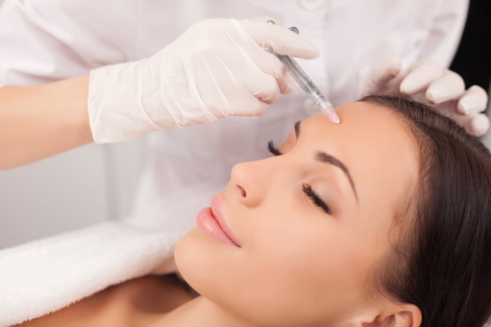 A woman getting neuromodulator injections in her forehead